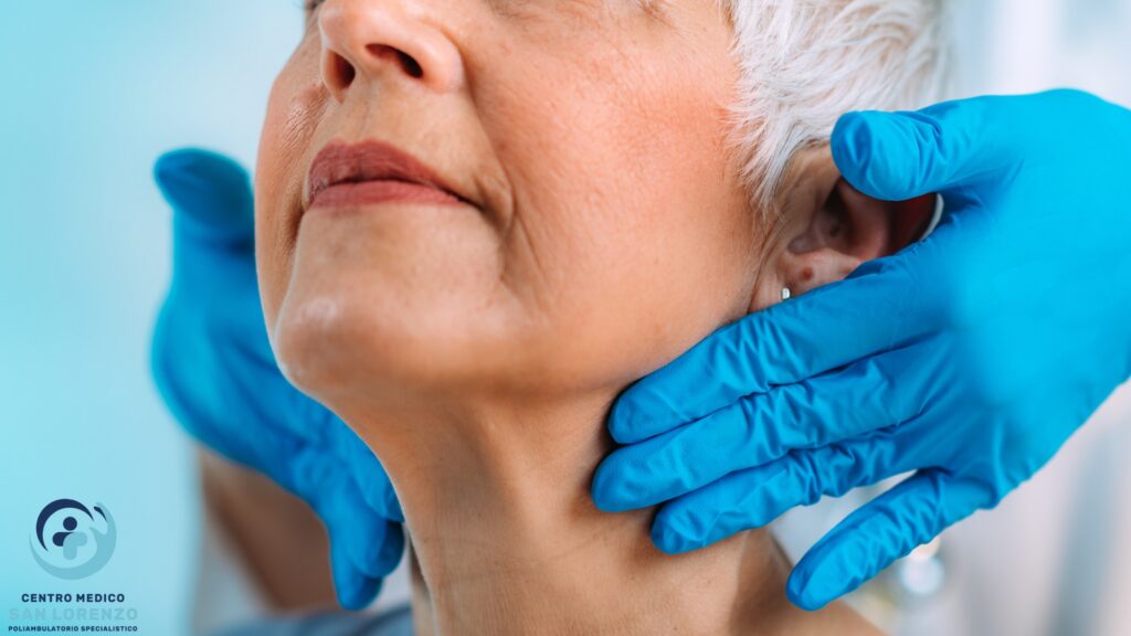 Medico palpa il collo di una paziente per la valutazione della tiroide